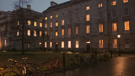 bicycles on the chain link fence outside the trinity college at night in dublin, ireland