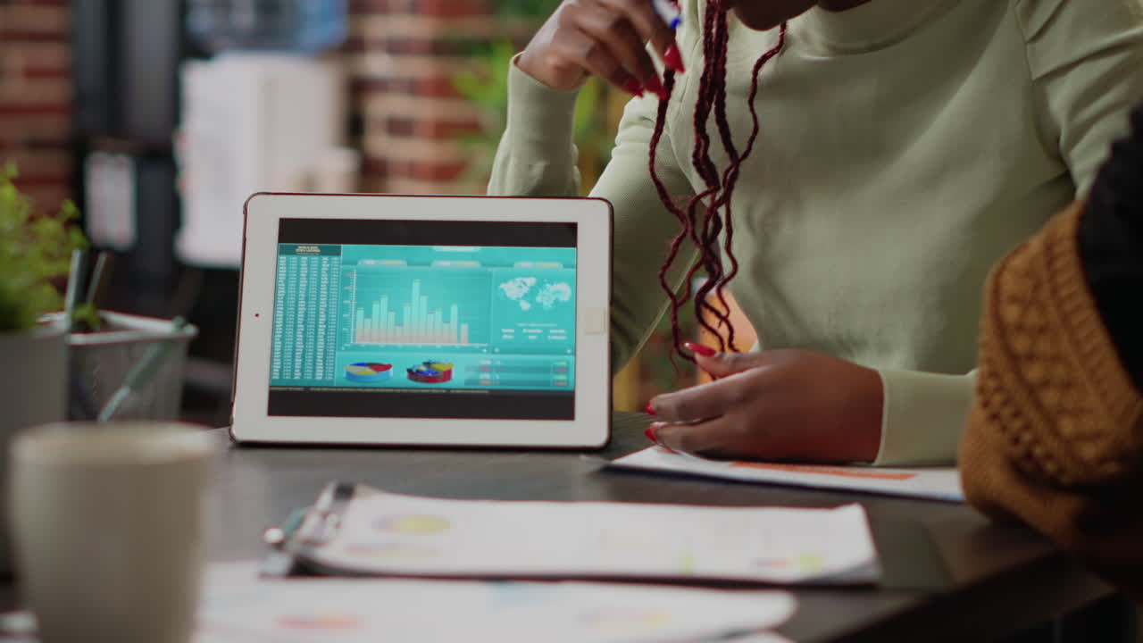 Diverse team of people analyzing data charts report on digital tablet