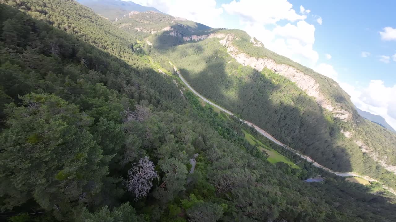 A drone performs a 180&deg; turn between two mountains, flying at low altitude, brushing the treetops
