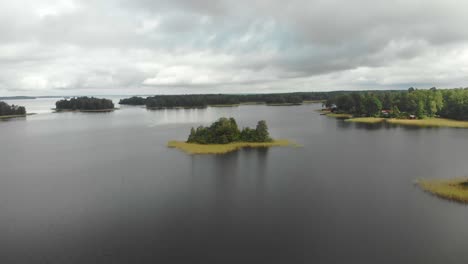 flying over ojarp lake near piksborg during cloudy day, aerial