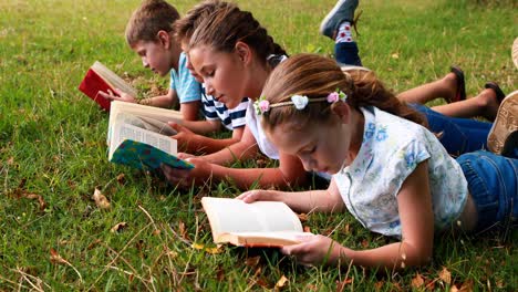 Kinder-Liegen-Im-Gras-Und-Lesen-Bücher