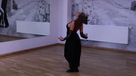 professional female dancer dances on the dance floor in front of the mirror