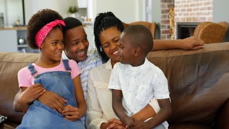 front view of young black family sitting on the couch in a comfortable home 4k
