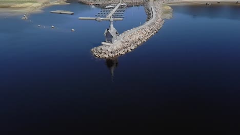 Rocky-shore-with-a-small-Orthodox-chapel-aerial-view