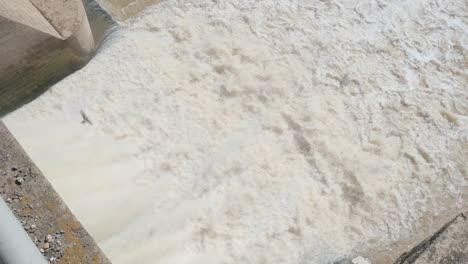 close-up of water rushing out of a sluice gate at a dam on the guadalquivir river