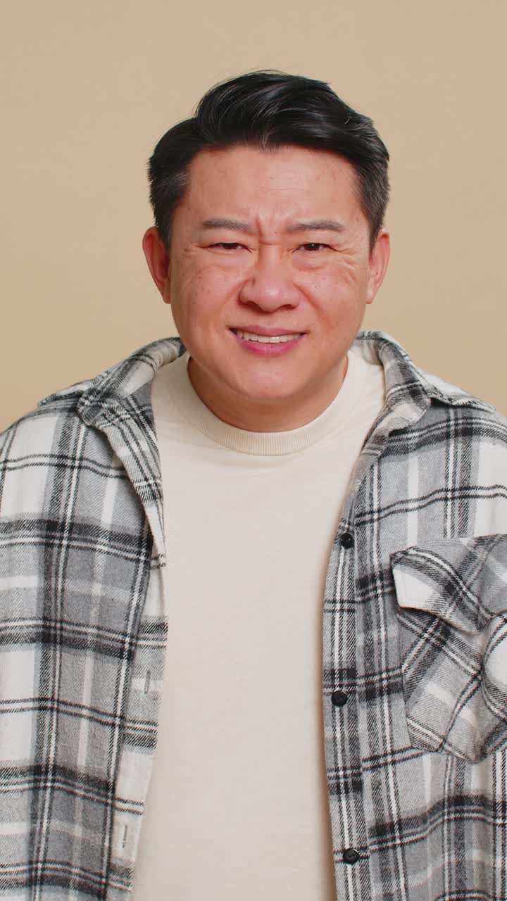 Asian man trying hear you looking confused and frowning keeping arm near ear for louder voice