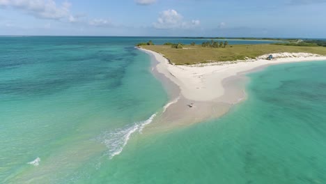 新婚夫婦坐在白色沙灘上,空中拍攝的娃娃在cayo de agua島的洛斯洛克斯