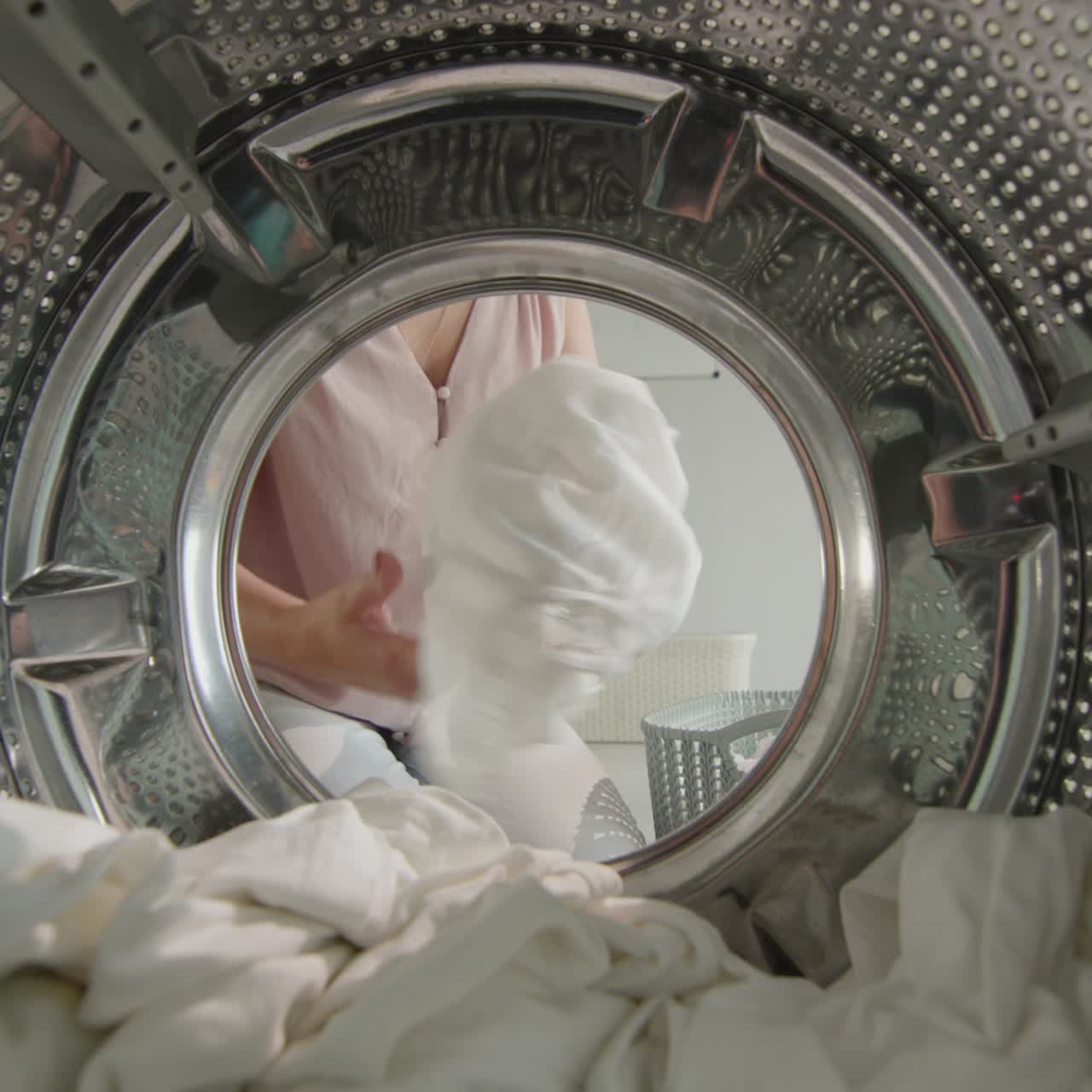 una mujer saca ropa lavada y limpia de la lavadora