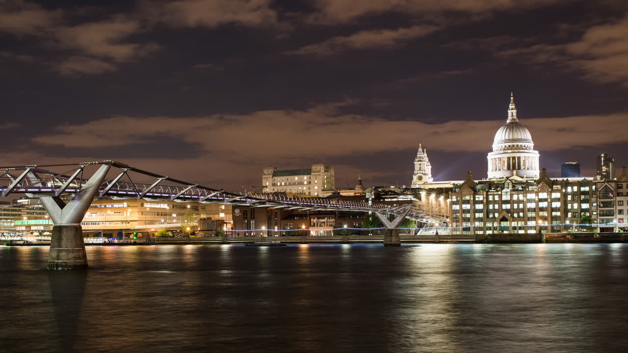 Timelapse of St Paul's Cathedral in London. Dusk turning into night. Boats cruising past on the River Thames