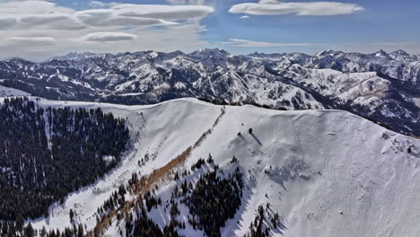 Park-City-Utah-Aerial-v38-aesthetic-nature-landscape,-flyover-mountain-ridge-capturing-beautiful-white-mountainscape-view-during-winter-season-on-a-sunny-day---Shot-with-Mavic-3-Cine---February-2022