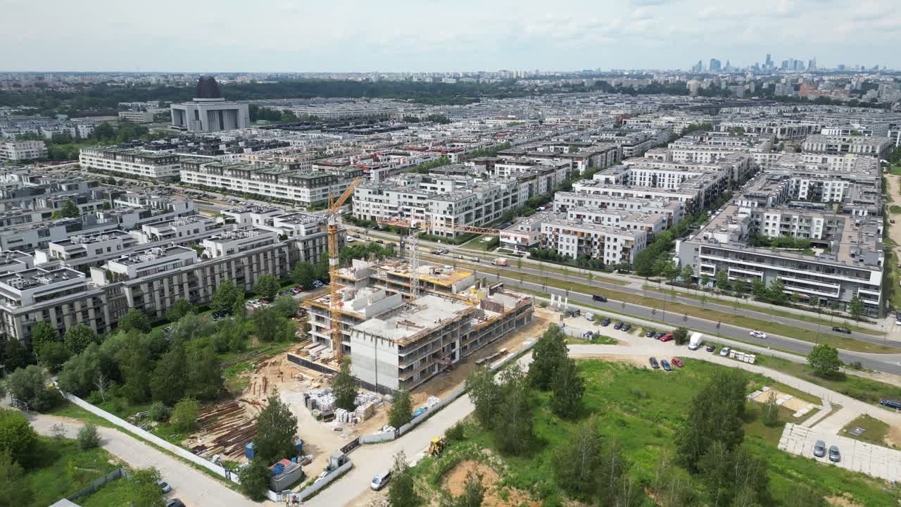 vista aérea de arriba hacia abajo en el techo de un edificio de apartamentos en construcción con una grúa de torre y muchos trabajadores colocando barras de metal