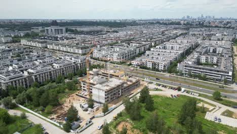 Aerial-top-down-view-on-the-rooftop-of-an-apartment-building-under-construction-with-tower-crane-and-a-lot-of-workers-laying-metal-rebar