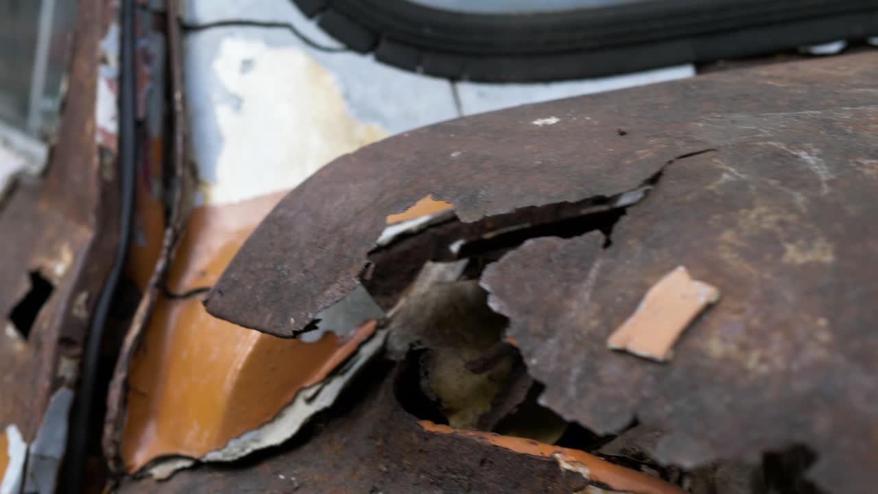 toma panorámica a través de la carrocería agrietada y deteriorada en un coche viejo, fiat 500, bangkok, tailandia