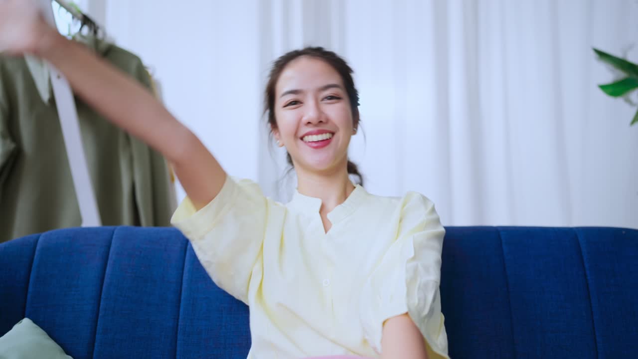 편안한 여가 아시아 여성 손은 음악과 함께 움직입니다 tv에서 스트리밍 공연 행복 웃음과 함께 집에 앉아 편안하게 앉아 콘서트 tv 프로그램을 평화롭게 즐기십시오.