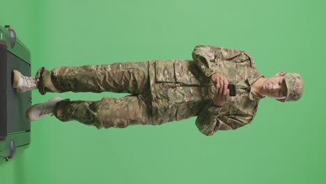 full body of asian man soldier using smartphone while walking in the green screen background studio