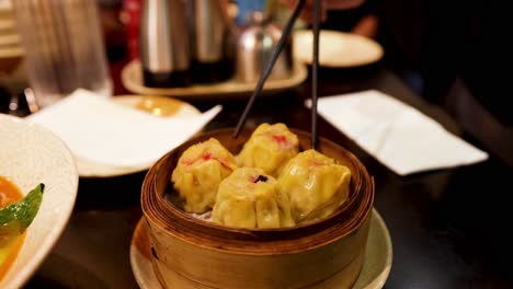 person picking up dumplings with chopsticks