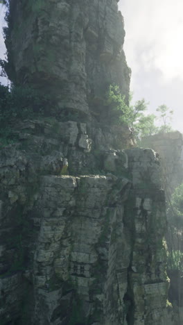 Majestic rock formation amidst lush greenery at sunrise