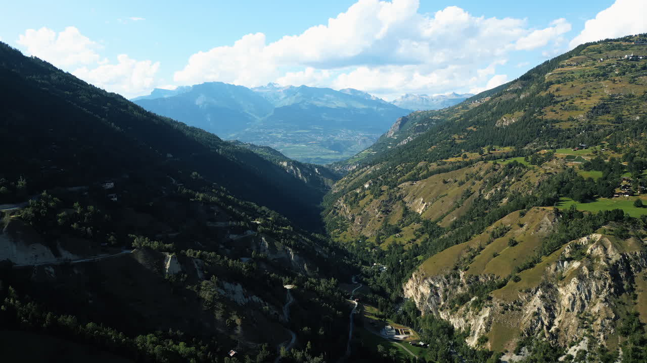 Aerial: Val d'Herens valley near fairy chimney rock formations of Euseigne during the day in canton of Valais, Switzerland, establishing drone shot