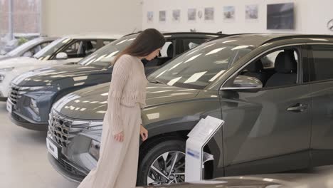 woman choosing a car in a car showroom