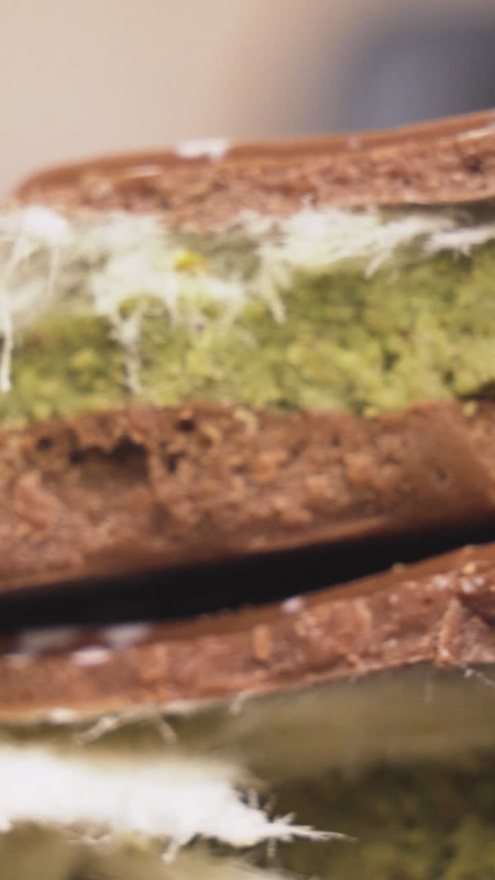 Vertical shot showcasing smooth chocolate from Dubai delicately sprinkled with crushed pistachios, perfect for high-end confectionery visuals