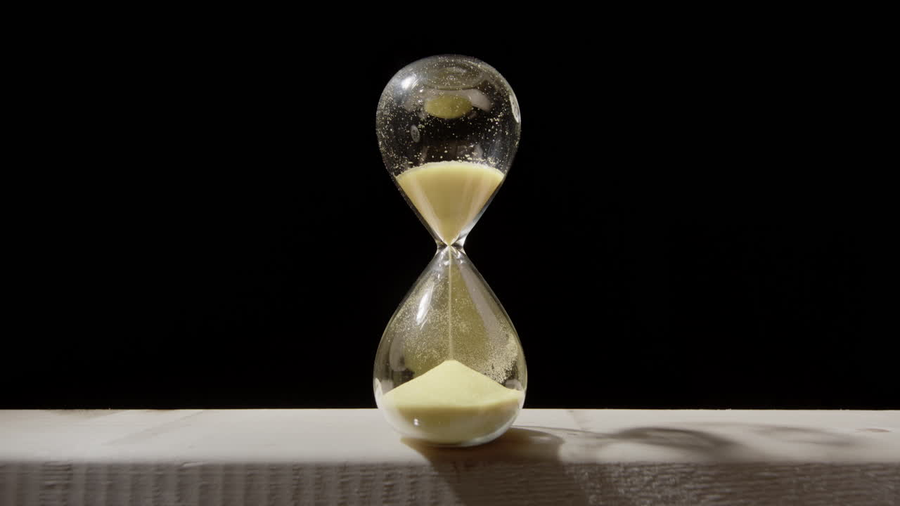 estático ancho de un gran reloj de arena amarillo en madera, estudio negro