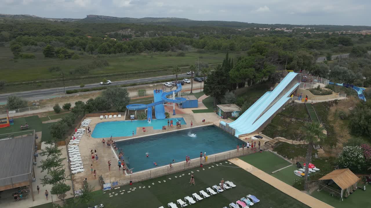 Aerial View of a Water Park with People Enjoying Slides and Swimming Pool