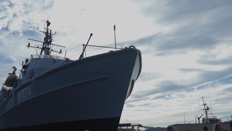 naval vessel at port under a cloudy sky