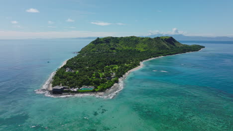 shallow reef system wrapping around tropical island with turquoise waters