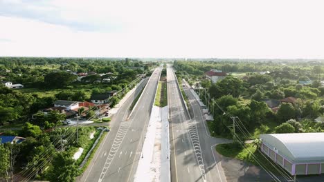 wild short of aerial view railway crossing bridge and tree forest countryside with traffic on the road in khonkaen, thailand