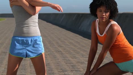 mujeres deportivas haciendo estiramientos juntas