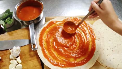 la mano del chef preparando la pizza