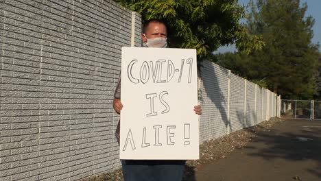 Manifestante-Anti-Covid-Con-Máscara-De-Malla---Covid-19-Es-Una-Toma-De-Seguimiento-De-Mentiras