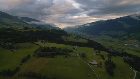 Drone-Aéreo-A-Lo-Largo-De-Un-Valle-De-Montaña-En-Los-Alpes-Austríacos-Con-Campos,-árboles-Y-Espectaculares-Nubes-Puestas-De-Sol-En-La-Naturaleza-En-Un-Deporte-De-Esquí-Senderismo-Y-Trekking-Lugar-De-Vacaciones-En-Un-Soleado-Día-De-Verano-Exuberante