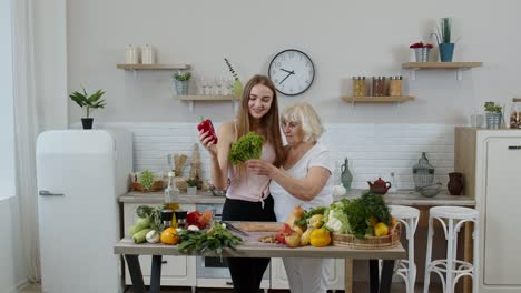 mature woman with grandchild girl recommending eating raw vegetable food. world vegan day concept