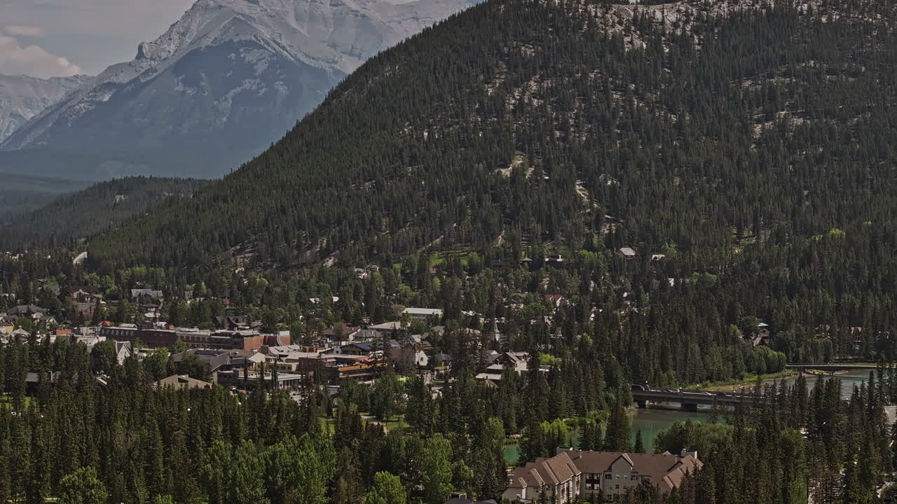 Banff, AB, Canada. Ripresa aerea zoomata v40 con drone di una valle boscosa che cattura un paesaggio pittoresco di una cittadina caratteristica immersa tra imponenti catene montuose - Ripreso con Mavic 3 Pro Cine - Luglio 2023