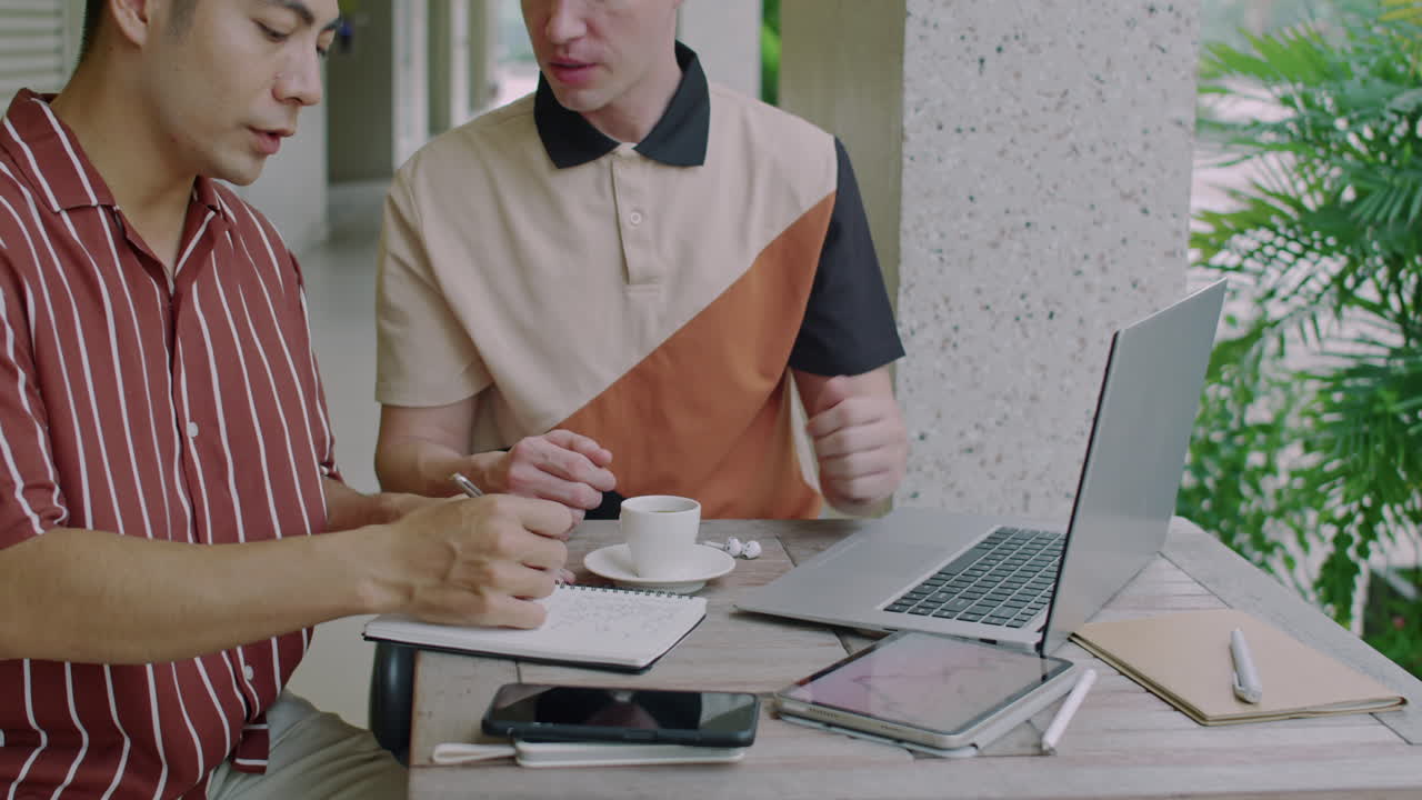 Male Investors Working in front of Laptop on Terrace