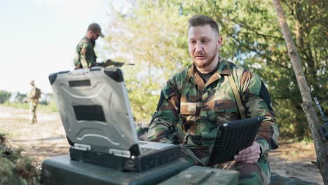 serious experienced army commander is in field having video conversation on computer with head of army base, giving him details of action discussing precautions taken, secret information