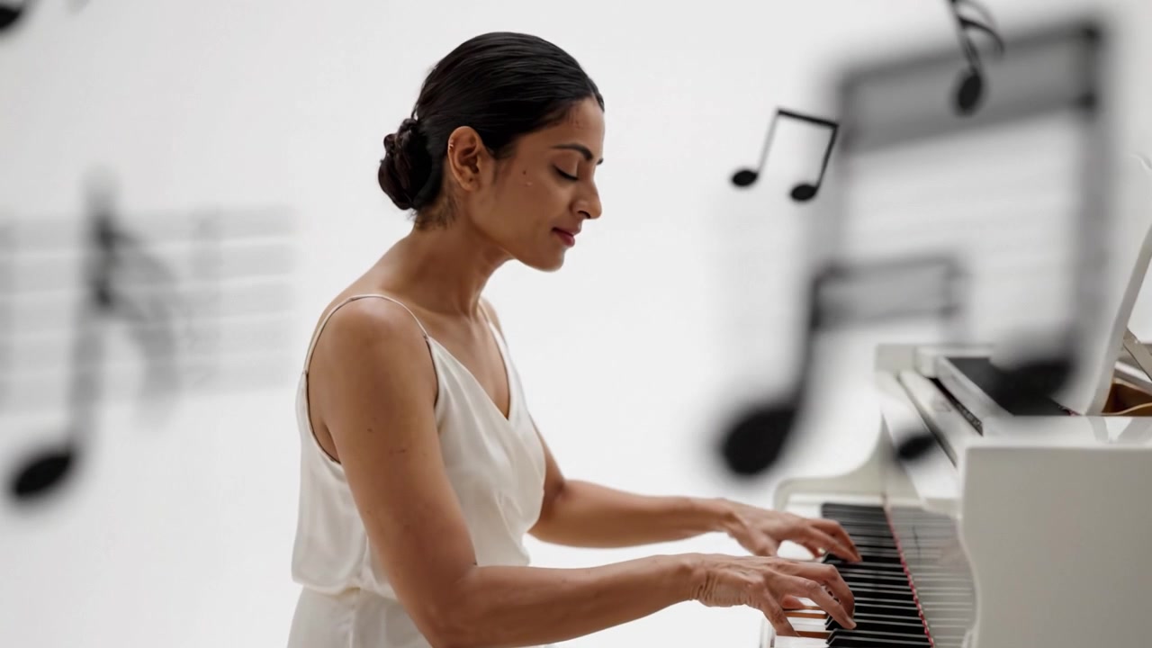 Una pianista di talento offre una splendida performance a un pianoforte a coda bianco in un ambiente minimalista, catturando il pubblico con la sua tecnica abile e la sua passione