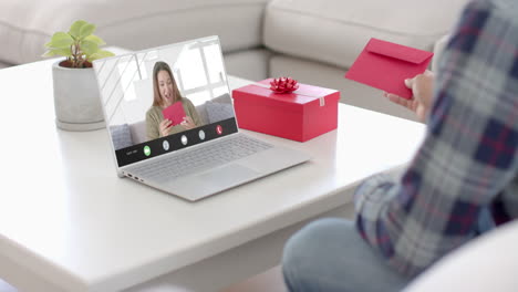 caucasian man holding envelope and talking with caucaslan woman on laptop screen