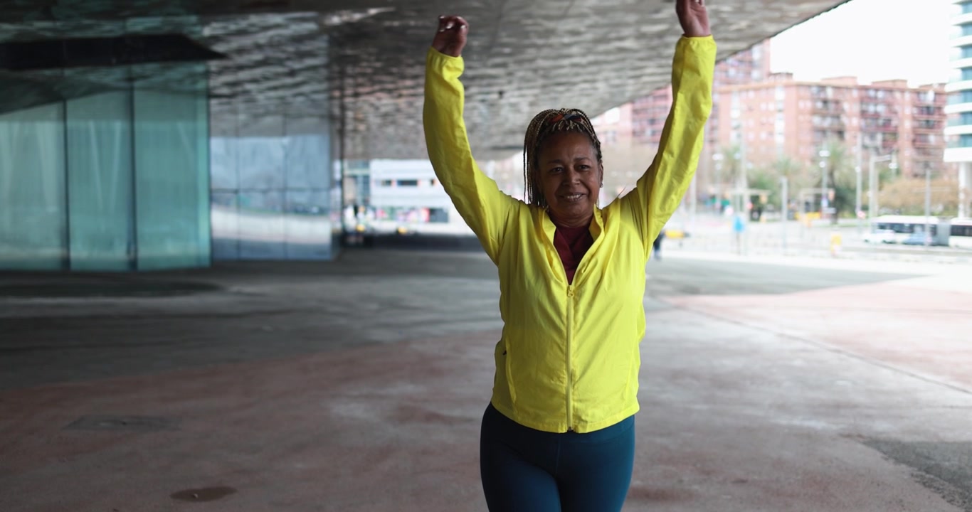 Mulher Madura Alongando os Braços ao Ar Livre em Cenário Urbano