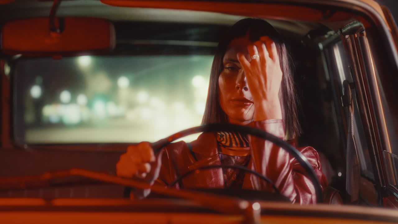 Portrait of Confident Woman Steering Retro Car through City at Night