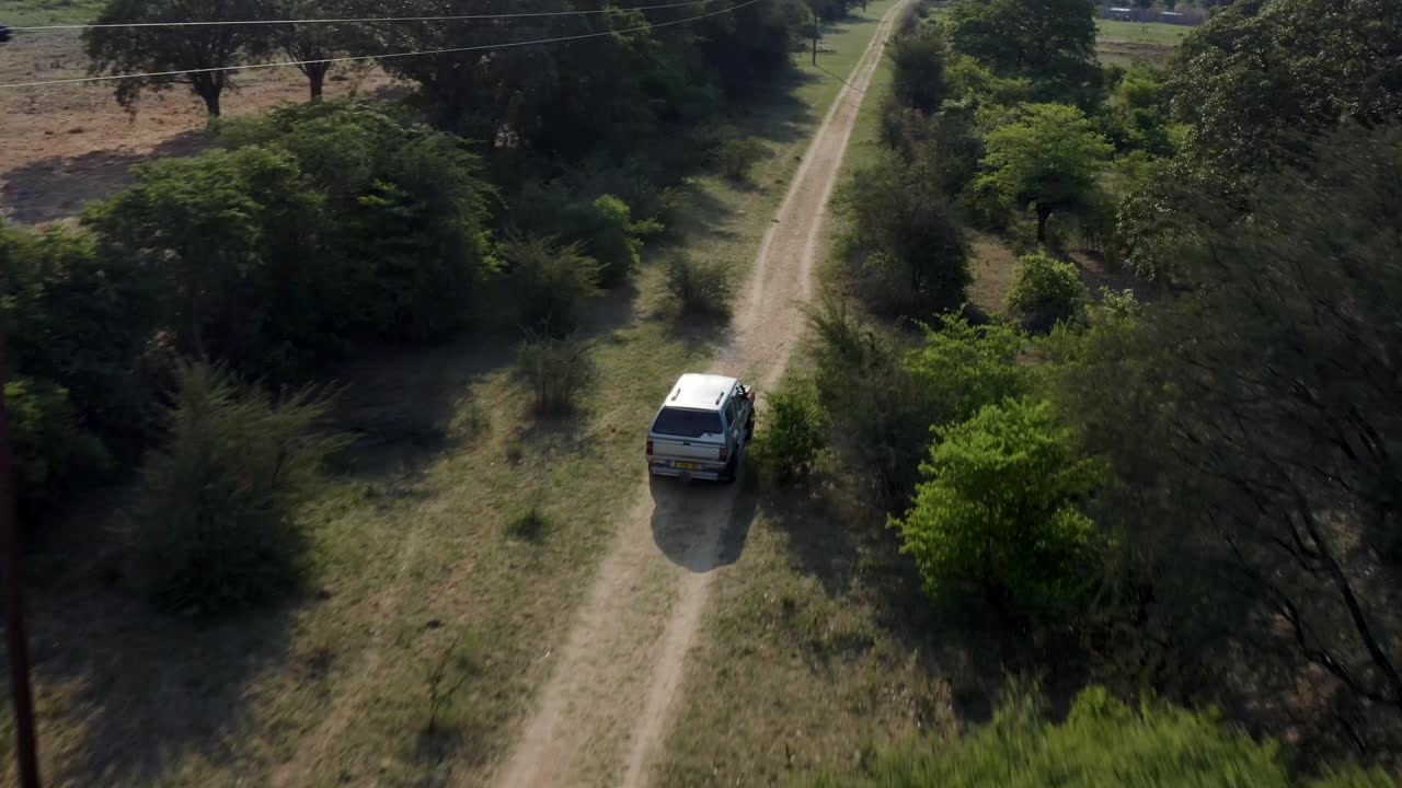 Veicolo fuoristrada 4x4 in guida su pista sterrata nella savana africana, vista aerea