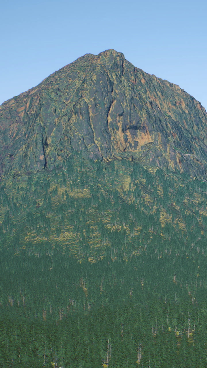 Majestic mountain rises above vibrant forest under clear blue sky