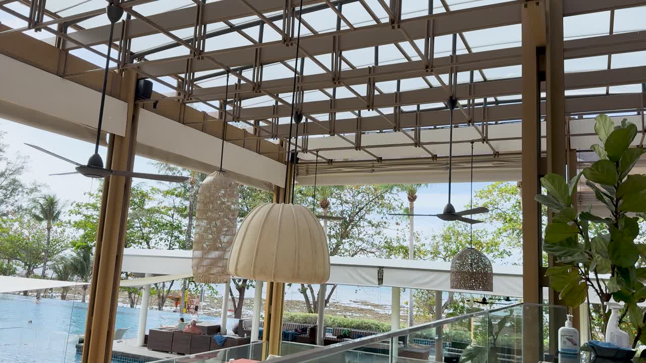 태국 푸켓에 있는 수영장 에 있는 조용한 식당, 잔잔한 초록색과 자연스러운 빛 아래의 현대적인 장식이 특징입니다.