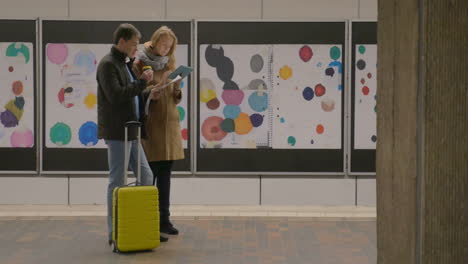 Young-travelers-with-coffee-and-pad-in-subway