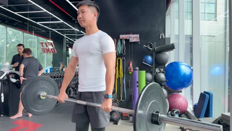 a man performs barbell deadlifts in a modern gym, focusing on strength and muscle building