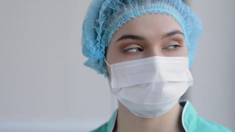 Portrait-Of-Beautiful-Nurse-With-Medical-Mask-Looking-At-Camera-And-Smiling