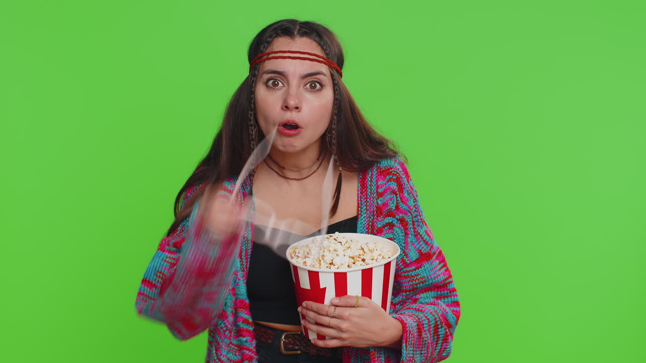 Kvinde med 3D-briller, der spiser popcorn og ser en spændende sportskamp, film eller online filmserie