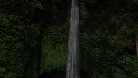 Bottom-to-top-view-of-a-majestic-waterfall-in-the-North-of-Bali-in-the-depths-of-jungle,-aerial