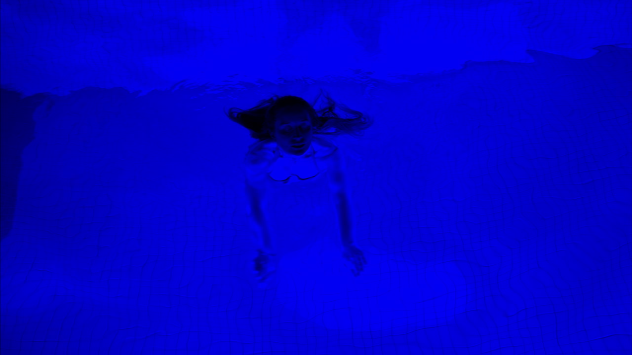Woman sweeting in a dark blue pool with neon lights at nigh